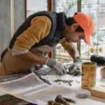 Photo d'un artisan du vitrail dans son atelier à Paris. vitraux, service après-vente, garantie