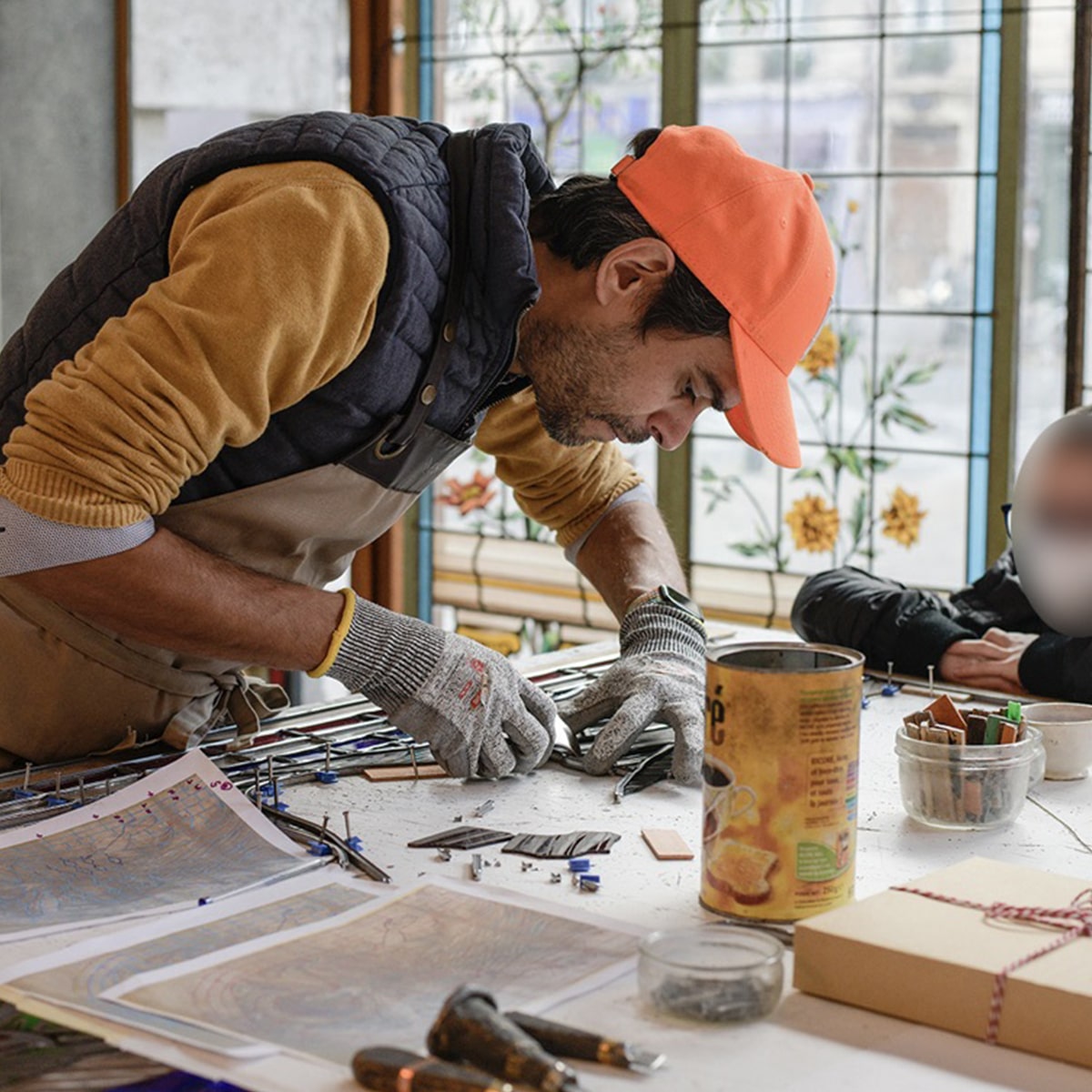 Sertissage du verre dans un atelier de vitrailliste à Paris